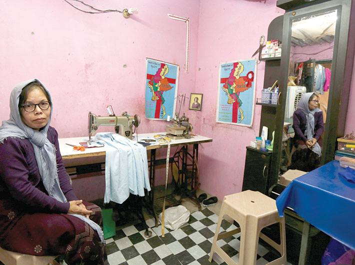 Two maps of Myanmar hang in a corner of Dimhoi’s tin-roofed room. But she dreams of being in Australia. Between the maps is a photograph of a middle-aged woman, who Dimhoi says helped her when she arrived in Delhi. The woman has made it to Australia. Dimhoi lives in the hope of reaching Australia. Or maybe, Canada or the US.
Robbed of property by the military government of Myanmar, she and her husband were press-ganged into carrying weapons from village to village for soldiers. One day, they got on a car that would take them to Aizawl, in Mizoram. During the escape, she was separated from her husband. “I don’t know if he’s alive or dead,” she says. <br><br>
It’s more than ten years since she came to India. She sews bedsheets, quilts and clothes to earn around Rs.2,000, which pays the rent. That may not be for long, for she says her eyesight is failing. The Chin refugee church helps out with rations, and so do fellow refugees. “I’m not happy here,” she says. “I can’t go back to my country. There’s nothing left there. I’m stuck here.”

